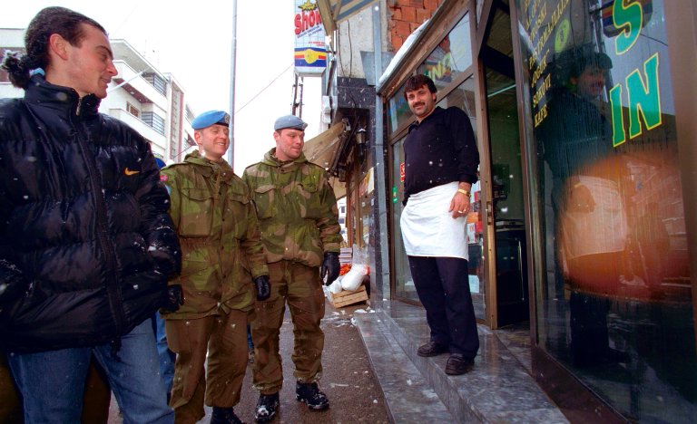 To norske soldater sammen med to innbyggere.